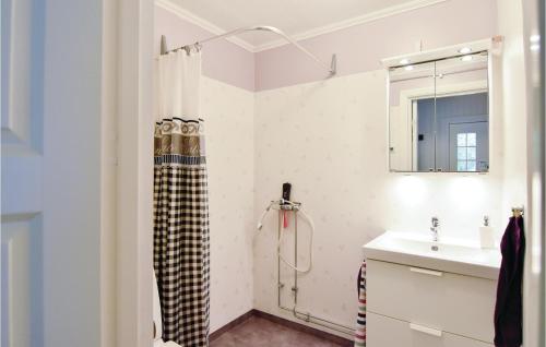 La salle de bains est pourvue d'un rideau de douche et d'un lavabo. dans l'établissement Lovely Home In lgars With Kitchen, à Älgarås
