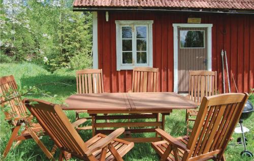 a wooden table and chairs in front of a red cabin at Kvighult in Forsvik