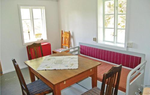 a dining room with a wooden table and two windows at Kvighult in Forsvik