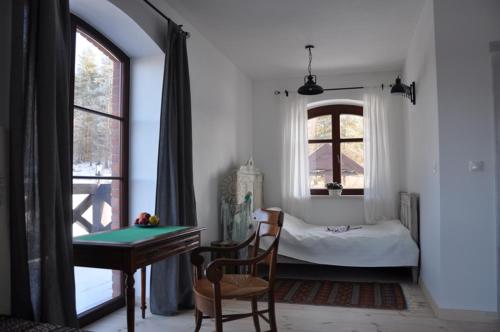 1 dormitorio con cama, escritorio y mesa en Zakątek Sary, en Jonkowo