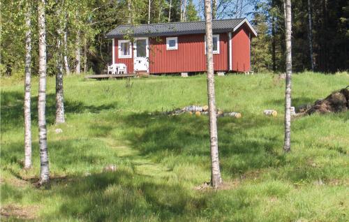 a red cabin in the middle of a field with trees at One-Bedroom Holiday Home In Ed in Fagerhult