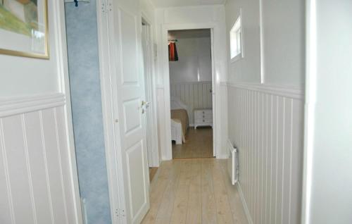 un couloir avec une porte blanche et une chambre avec un lit dans l'établissement Cozy Home In Henn With Kitchen, à Henån