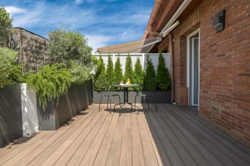 a wooden deck with a table and chairs on a house at Aparthotel Mariano Cubi Barcelona in Barcelona