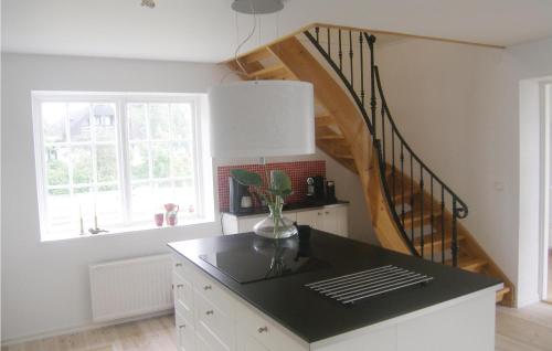 a kitchen with a black counter top and a staircase at Nice Home In Beddingestrand With Sauna in Beddinge Strand