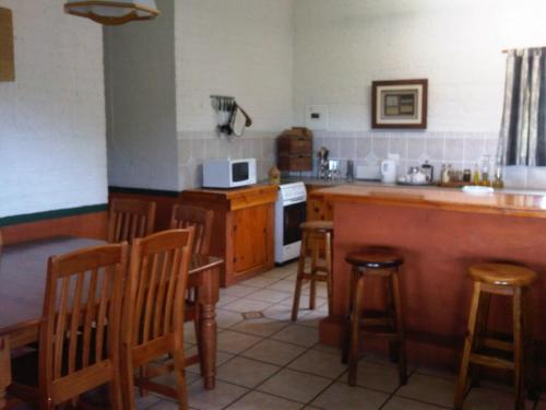 a kitchen with a counter and some wooden stools at Pumula Guest Farm in Fouriesburg