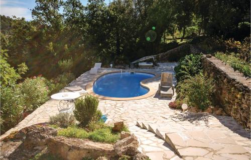 une arrière-cour avec une piscine et un mur en pierre dans l'établissement Lovely Home In St Anastasie S Issoles, à Forcalqueiret