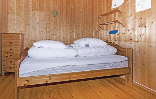 a bed in a wooden room with white pillows at Stunning Home In Steinst With Wifi in Øystese