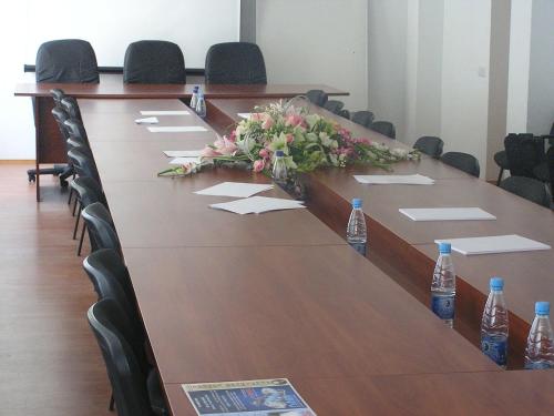 a long table in a room with chairs and flowers at Holosiyvsky Hotel in Kyiv
