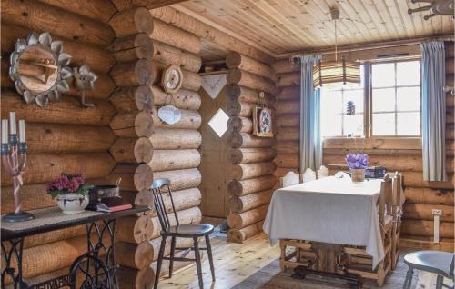 comedor en una cabaña de madera con mesa y sillas en Nice Home In Hgsby With Kitchen en Högsby