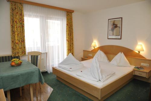 A bed or beds in a room at Hotel Alpina