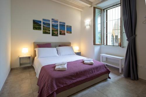 a bedroom with a bed with two towels on it at CASA VACANZE MARCONI 22 in Marone