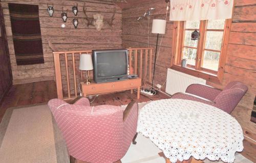 a living room with a table and a tv at 3 Bedroom Stunning Home In Alvesta in Alvesta