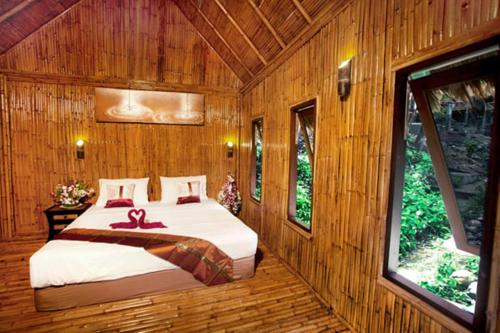 a bedroom with a bed in a wooden room at The Cove Phi Phi in Phi Phi Don