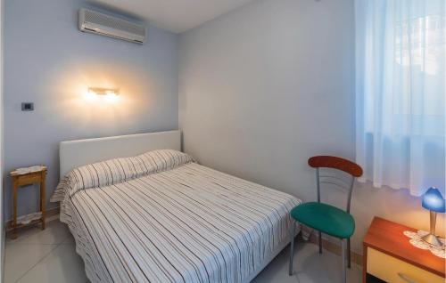 ein kleines Schlafzimmer mit einem Bett und einem Stuhl in der Unterkunft 1 Bedroom Stunning Apartment In Opatija in Opatija