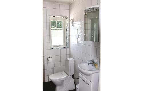 Baño blanco con aseo y lavamanos en Lovely Home In Lttorp With Wifi, en Norrböda