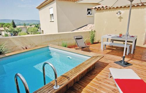 - une piscine sur une terrasse avec une table et un parasol dans l'établissement Amazing Home In Laudun-Lardoise, à Laudun-l'Ardoise