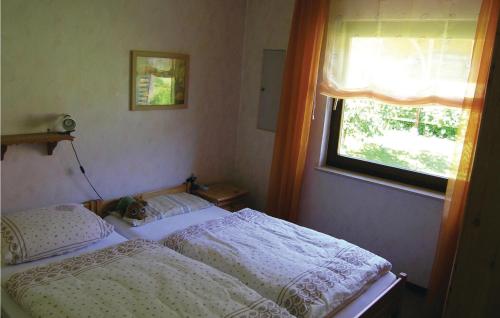 ein kleines Schlafzimmer mit einem Bett und einem Fenster in der Unterkunft Beautiful Home In Dautphetal With 2 Bedrooms in Holzhausen