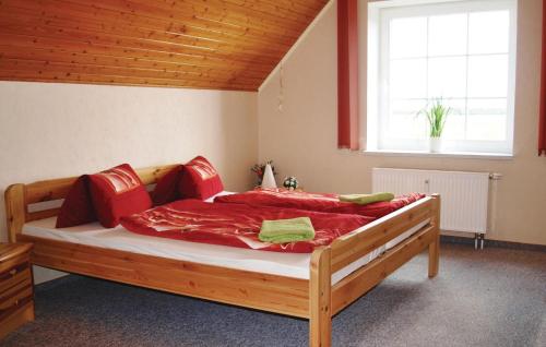 Schlafzimmer mit einem großen Bett mit roter Bettwäsche und einem Fenster in der Unterkunft 2 Bedroom Pet Friendly Apartment In Mirow Ot Qualzow in Qualzow