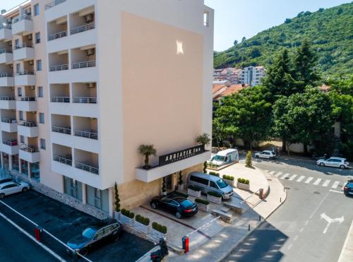 an apartment building with cars parked in a parking lot at Adriatik Lux Apartments in Budva