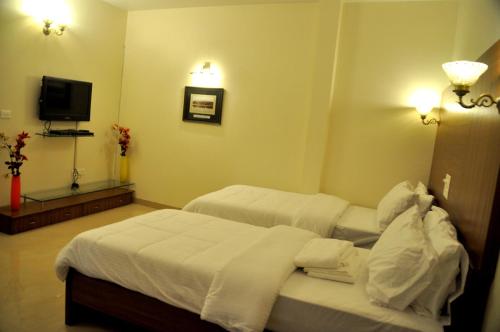 a hotel room with two beds and a television at The Bhopal Grande in Bhopal