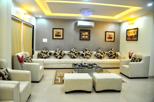 a living room with a couch and chairs and a table at The Bhopal Grande in Bhopal