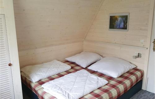 Bett in einem Zimmer mit zwei Kissen darauf in der Unterkunft Ferienhaus Bootshaus Nr. V in Teterow