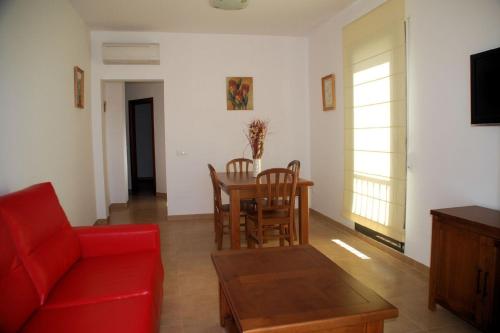 a living room with a red couch and a table at Apartamentos Plaza in Nerja
