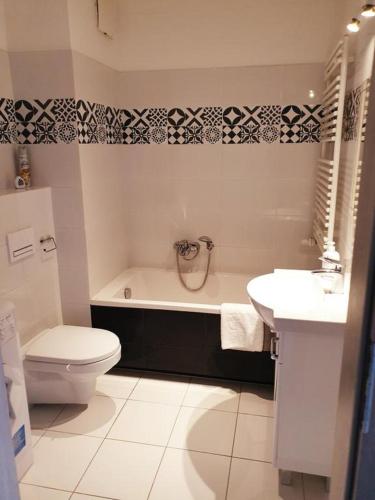 a bathroom with a tub and a toilet and a sink at Apartamenty Promenada in Warsaw