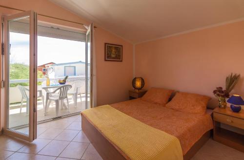 a bedroom with a bed and a balcony with a table at Fisa Apartments in Vir