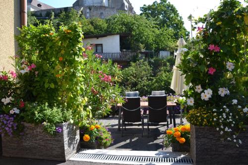 patio z krzesłami, kwiatami i parasolem w obiekcie Haus Lindenhofer w mieście Emmersdorf an der Donau