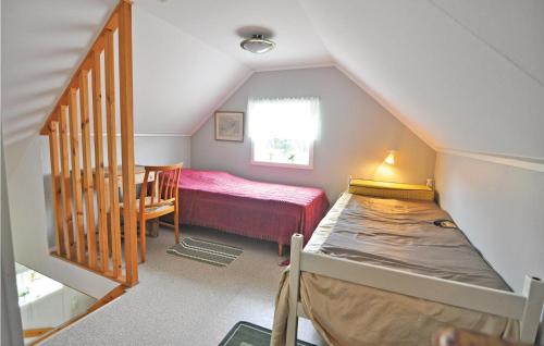 a attic room with a bed and a staircase at Holiday Home Trollungebyn Dalskog in Dalskog