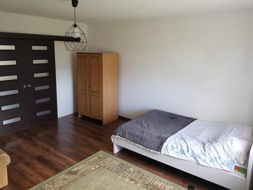 レンボルクにあるDom prywatnyのベッドルーム1室(ベッド1台付)、木製キャビネットが備わります。