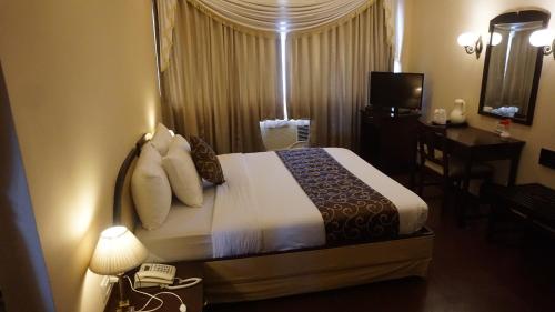 Hotel Poonja Internationalにあるベッド