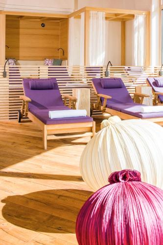 a room with purple chairs and a table at Haller's Geniesserhotel in Mittelberg