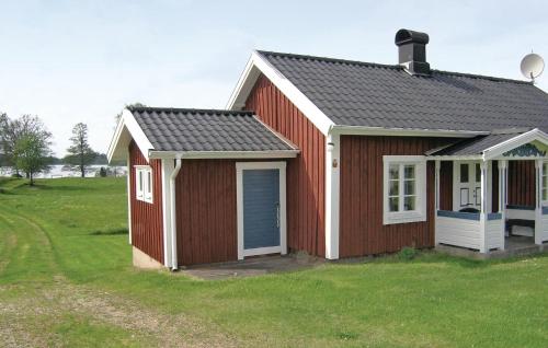a red and white house with a grass yard at Awesome Home In Ambjörnarp in Ambjörnarp