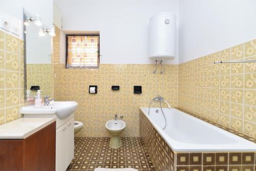łazienka z wanną, toaletą i umywalką w obiekcie Apartment Milka 1950 w Fažanie