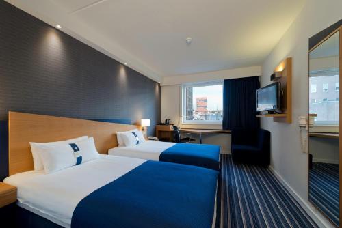 Pokój hotelowy z dużym łóżkiem i telewizorem w obiekcie Holiday Inn Express Antwerpen City North, an IHG Hotel w Antwerpii