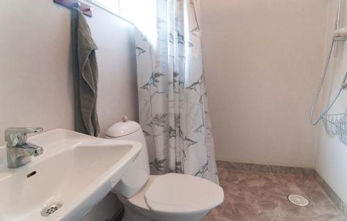 a bathroom with a white toilet and a sink at Awesome Home In Lrbro With 1 Bedrooms in Ire