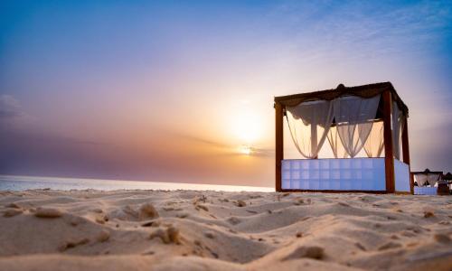 a bed in the sand on a beach at Caesar Bay Resort in Marsa Matruh