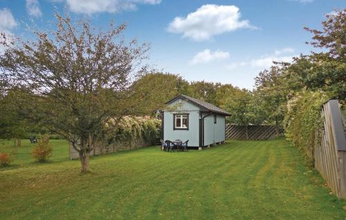 a small house in a yard next to a fence at Beautiful Home In Gäsrsnäs With Wifi in Skräddaröd