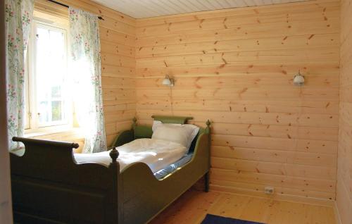 a bedroom with a bed in a room with wooden walls at Haug Isakplassen in Heggje