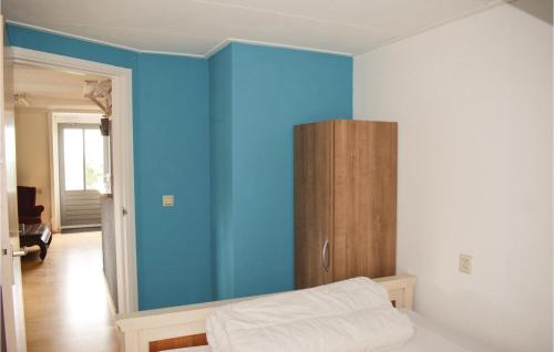 ein Schlafzimmer mit blauen Wänden und einem Holzschrank in der Unterkunft De Eekhof - Appartement 9 in Hindeloopen