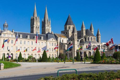 a large building with flags in front of it at Best Western Plus Le Moderne in Caen