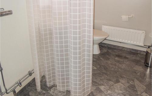 a bathroom with a toilet and a shower curtain at Nice Home In Urshult With House Sea View in Urshult