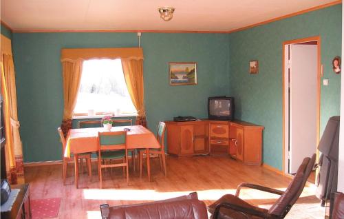a living room with a table and a television at Nice Home In Sirevåg With Kitchen in Sirevåg