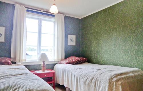 two beds in a room with green walls and a window at 3 Bedroom Nice Home In Mariannelund in Svenstorp