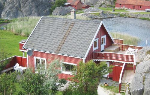 a red house with a porch and a balcony at Nice Home In Sirevåg With Kitchen in Sirevåg