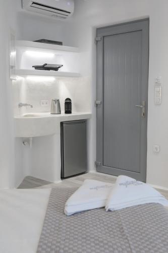 a bathroom with a bed and a sink and a door at Majestique of Naxos luxury suites in Naxos Chora