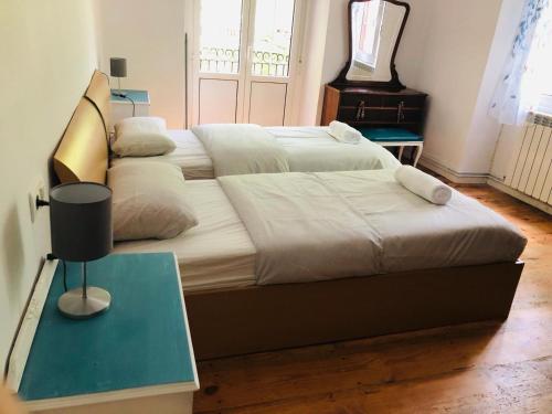 a bedroom with two beds and a table with a lamp at ordizia piso con vistas al parque in Villafranca de Ordizia