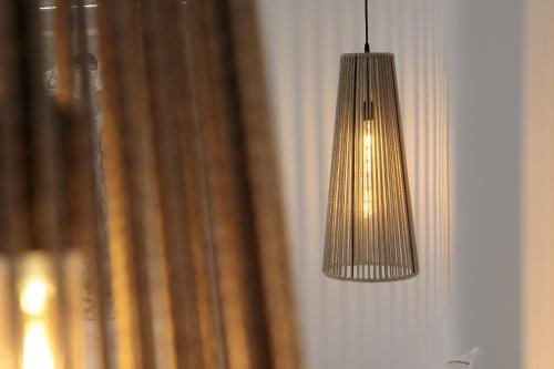 a light hanging from a wall next to a curtain at Majestique of Naxos luxury suites in Naxos Chora